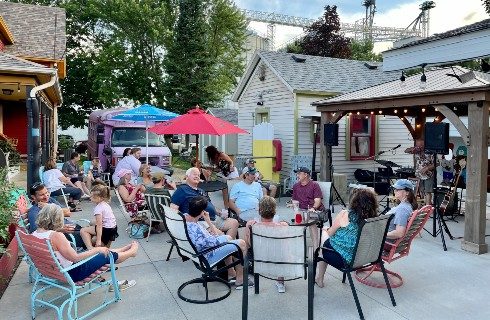 An outdoor patio of a brewery with groups of people sitting and talking