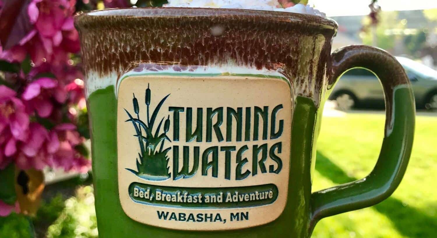 Green and brown ceramic mug with the logo for Turning Waters Bed, Breakfast and Brewery