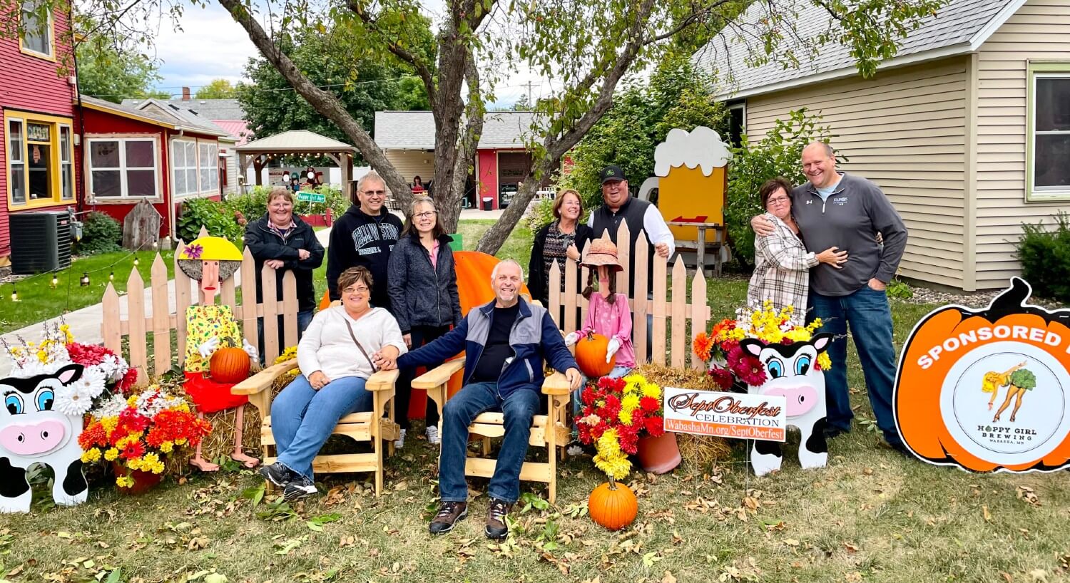 A group of people posing for a piicture outside of a brewery and bed and breakfast