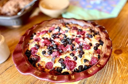 Dining table with a breakfast dish full of berries in a red pie plate