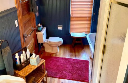 Blue and white bathroom with claw foot tub, toilet, stand up shower and pedestal sink